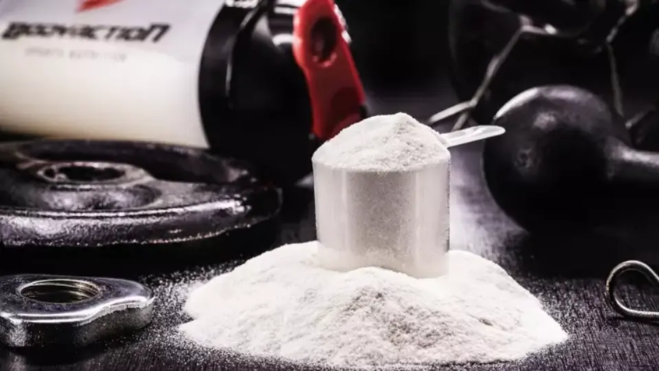 Dicas para ter uma alimentação saudável 6 Benefícios da Creatina: na imagem vemos uma quantidade de creatina sobre uma mesa preta com um scoop em cima.