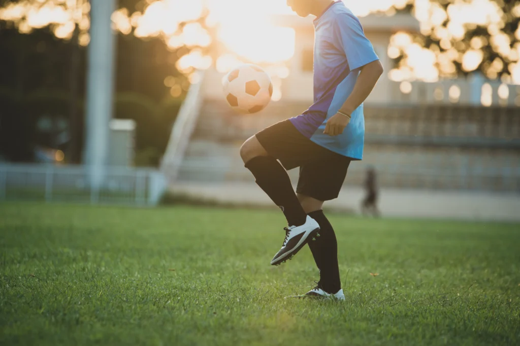 jogador de futebol fazendo embaixadinhas. 