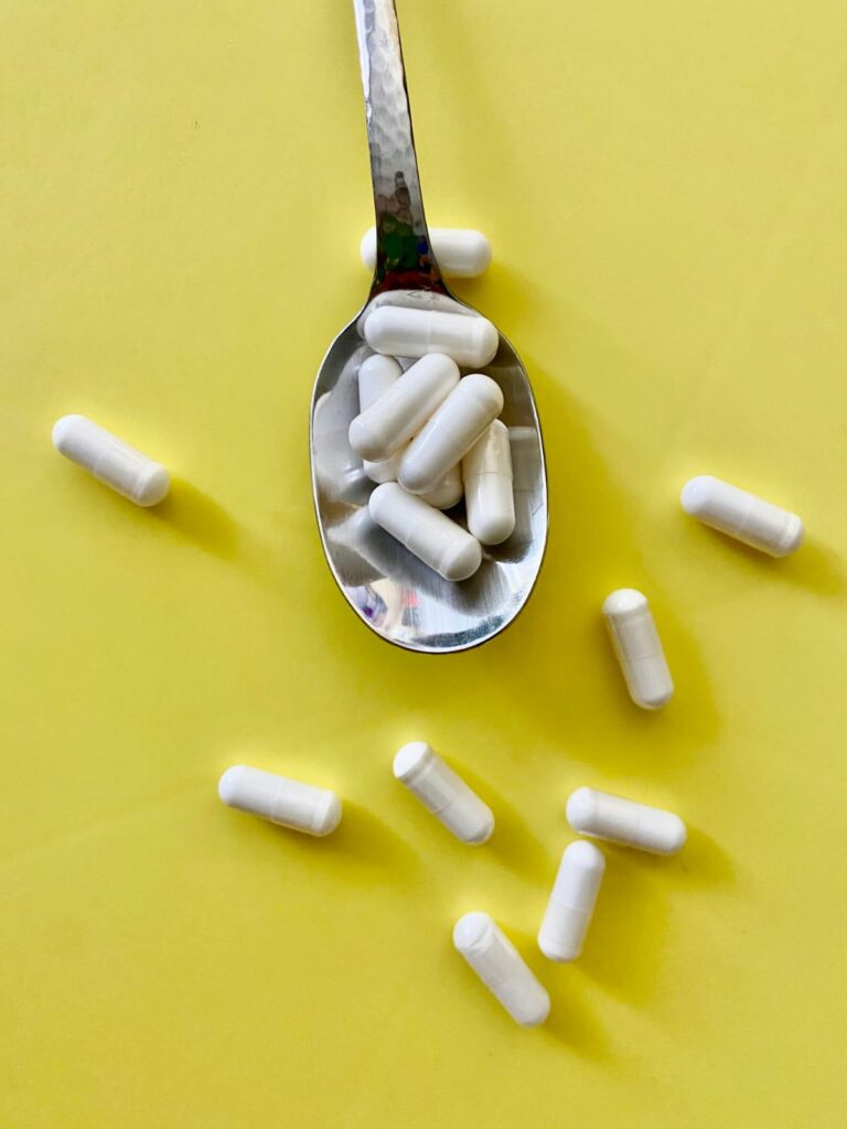 Cápsulas e comprimidos de medicamentos sobre uma mesa.