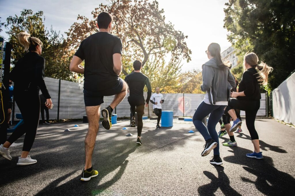 Grupo de pessoas se exercitando em ambiente coletivo, imagem borrada reforçando a importância da prática de exercícios no manejo da artrite e artrose.