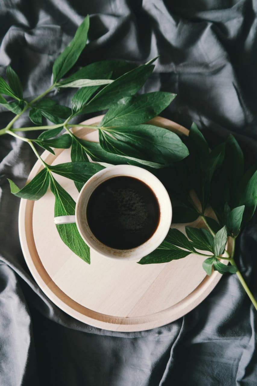 Xícara de café vista de cima representa o uso cotidiano da cafeína, com destaque para a questão central do artigo: cafeína emagrece?