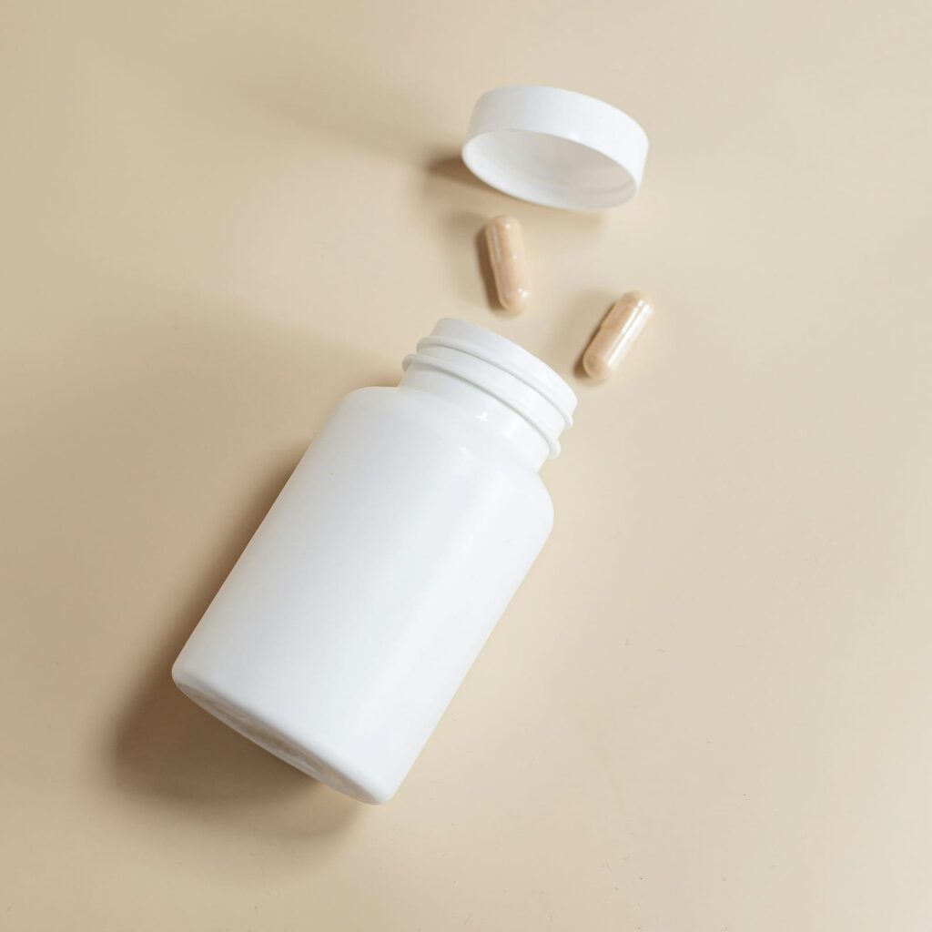 Frasco de remédio com cápsulas ao lado, representando tratamento para herpes zoster.