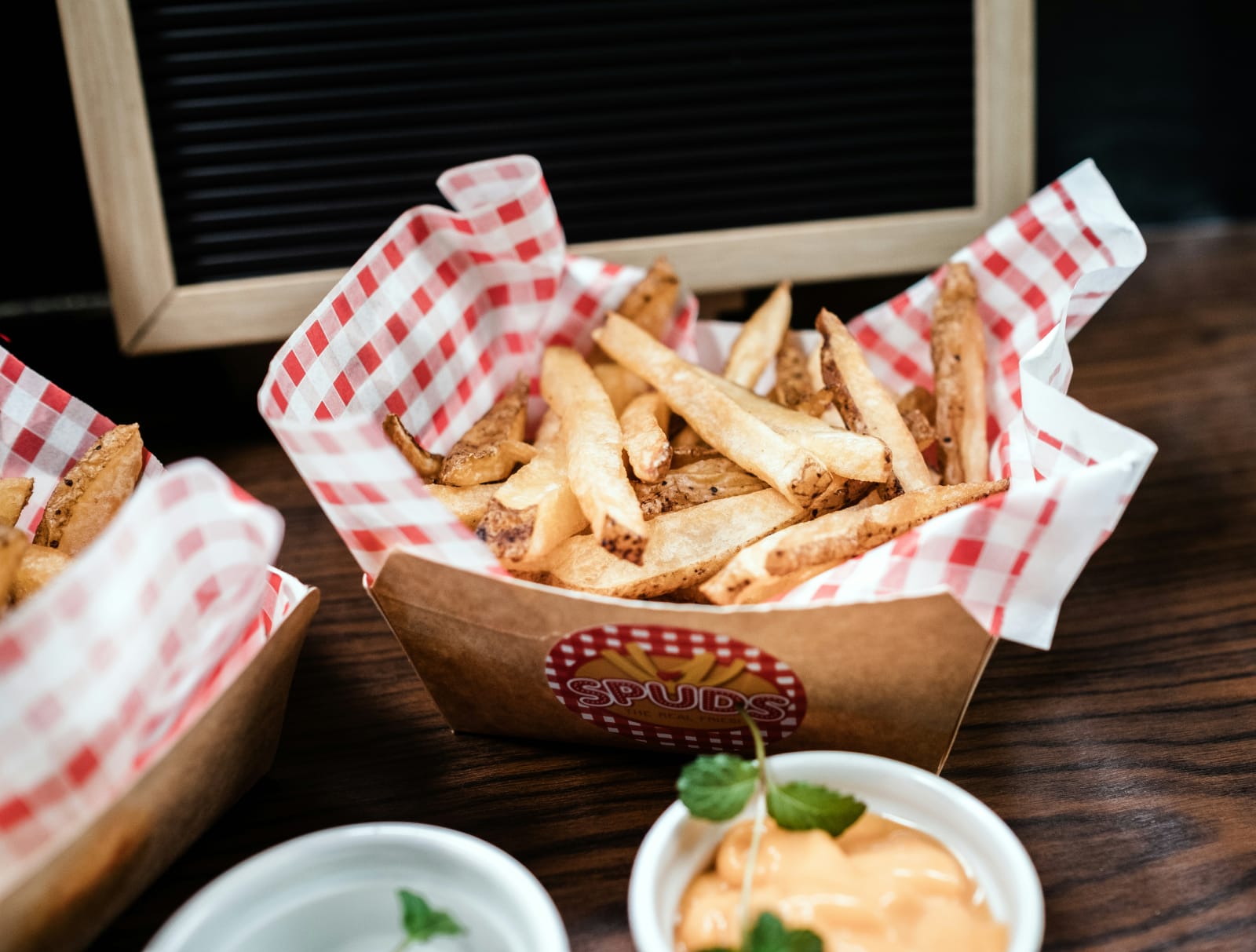 Cesta com batatas fritas e molho, alimentos que podem agravar a retenção de líquidos.
