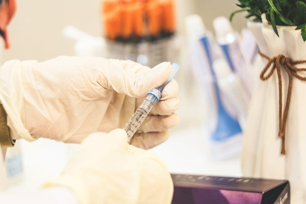 Profissional de saúde preparando seringa para tratamento da febre reumática.