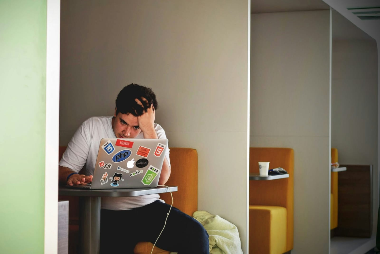 Homem estressado diante do notebook, representando os efeitos do estresse e do hormônio cortisol.