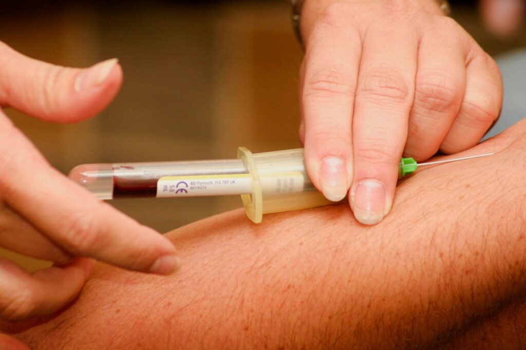 profissional de saúde coletando sangue do braço do paciente para diagnóstico dos tipos de anemia.