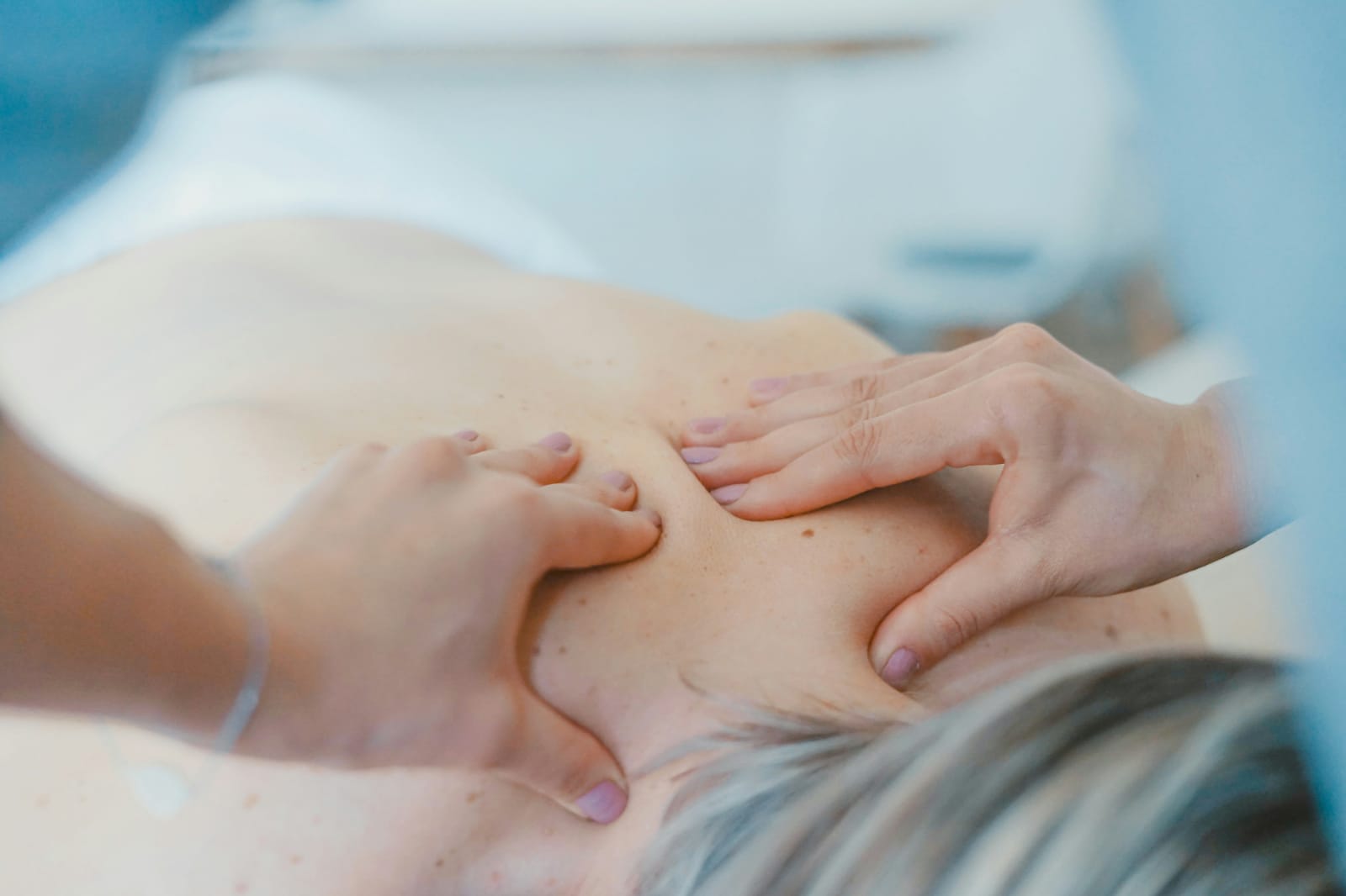 Pessoa recebendo técnica suave de massagem nas costas, semelhante à drenagem linfática, associada à dúvida sobre se drenagem linfática emagrece.