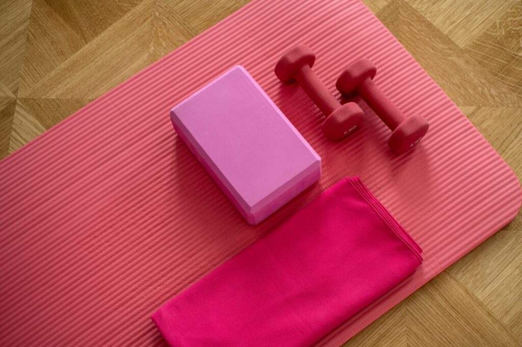Equipamentos de exercício físico sobre tapete, representando a relação entre exercícios e doenças crônicas no cuidado com a saúde.
